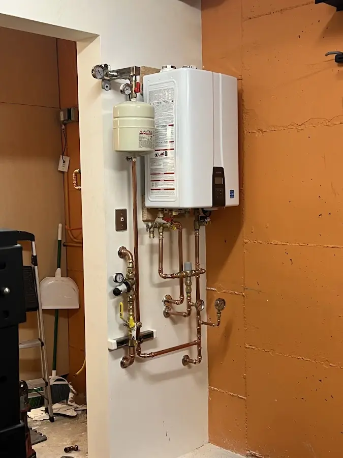 Plumbing technician inspecting water heater connections in Kingman